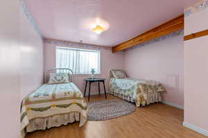 Bedroom with hardwood / wood-style floors and a textured ceiling