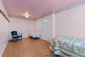 Bedroom with light hardwood / wood-style floors and a textured ceiling