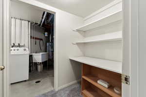 Interior space with concrete floors, washer / clothes dryer, a textured ceiling, and gas water heater