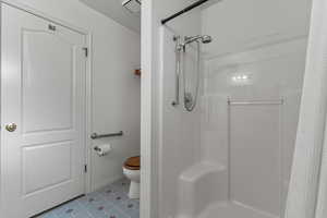 Bathroom with tile patterned flooring, toilet, a textured ceiling, and a shower with shower curtain