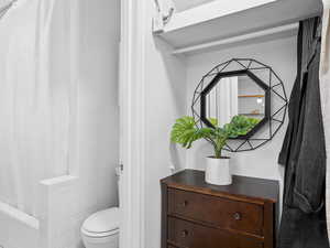 Bathroom featuring shower / bathtub combination with curtain and toilet