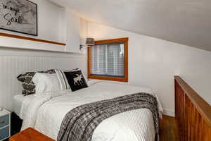 Bedroom (Queen bed) featuring hardwood / wood-style flooring and vaulted ceiling