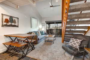 Living room featuring ceiling fan, beam ceiling, high vaulted ceiling