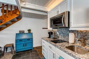 Kitchen with sink, white cabinetry, granite counters, tasteful backsplash, and black electric cooktop