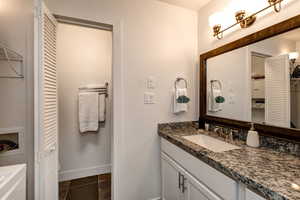 Bathroom featuring tile patterned flooring, vanity, and large mirror