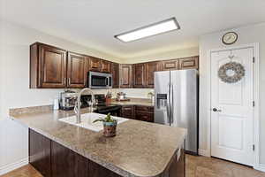 Kitchen featuring large sink and wood cabinets.