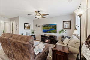 Living room with ceiling fan and a fireplace