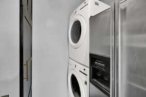 Clothes washing area featuring stacked washer and clothes dryer