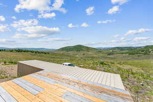 Wooden terrace featuring a rural view and a mountain view