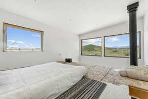 Bedroom featuring a mountain view and multiple windows