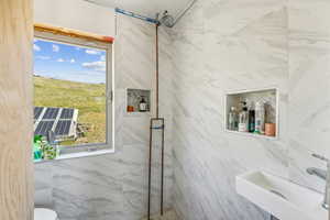 Bathroom with tiled shower and sink