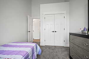 Bedroom with dark carpet and a closet