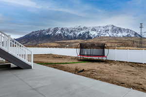 View of yard featuring a mountain view, a patio area, and a trampoline