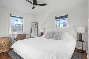 Bedroom with multiple windows, dark hardwood / wood-style flooring, and ceiling fan