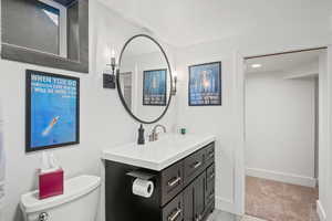 Bathroom with vanity, toilet, and a textured ceiling