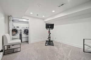 Laundry room with separate washer and dryer and carpet