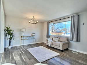 Sitting room featuring dark hardwood / wood-style floors and a notable chandelier