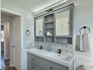 Bathroom featuring backsplash, hardwood / wood-style flooring, and vanity