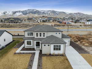 View of front facade featuring a garage, a mountain view, and a front yard