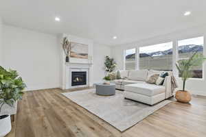 Living room featuring a mountain view, a high end fireplace, and light LVP flooring