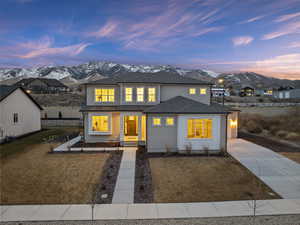 View of front facade featuring central AC unit, a mountain view, and a lawn