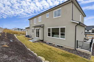 Rear view of house featuring a yard, garden and separate entry for basement