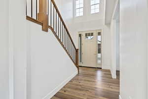 Foyer entrance featuring a high ceiling and light wood-LVP flooring