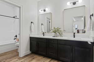 Full second bathroom upstairs featuring shower/tub combination, toilet, light LVP woodlike flooring, and vanity