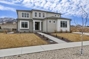 View of front facade featuring a mountain view and a front lawn