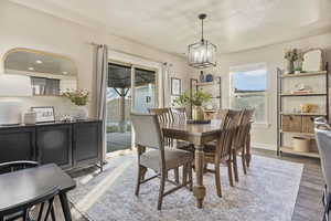 Dining room with wood-type flooring, a chandelier, and a textured ceiling