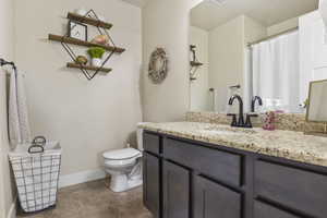 Bathroom featuring vanity, toilet, and tileflooring