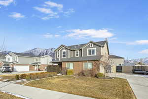 View of front of property featuring a mountain view, a garage, and a front lawn