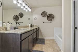 Bathroom featuring double vanity and a washtub