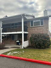 Exterior space featuring a balcony, a patio area, and a lawn