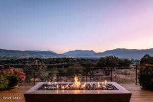 Deck at dusk with a mountain view and a fire pit