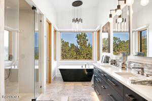 Bathroom featuring vanity, a notable chandelier, and independent shower and bath