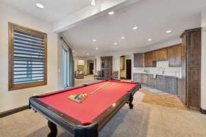 Playroom with sink, light colored carpet, beam ceiling, and billiards