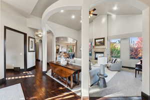 Living room with high vaulted ceiling, dark hardwood / wood-style floors, and ceiling fan