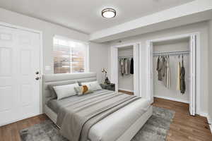 Bedroom featuring two closets and dark hardwood / wood-style floors