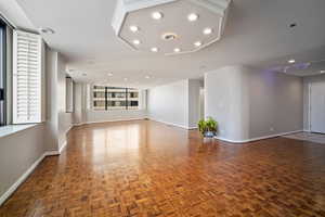 Unfurnished living room featuring dark parquet floors