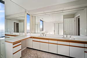 Bathroom with vanity, a shower with door, and plenty of natural light