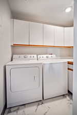 Washroom featuring independent washer and dryer and cabinets