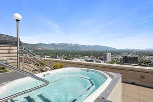 View of pool with an outdoor hot tub and a mountain view