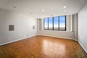 Unfurnished room featuring dark parquet flooring