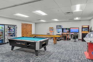 Rec room featuring dark colored carpet and a drop ceiling