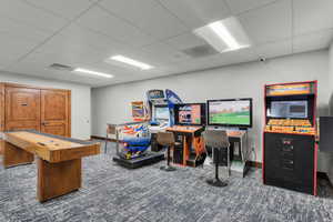 Game room featuring a paneled ceiling and dark carpet