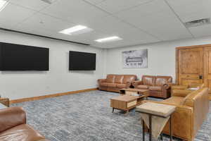 Carpeted living room with a drop ceiling