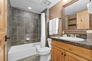 Full bathroom with tile patterned flooring, vanity, toilet, and shower / bath combo with shower curtain