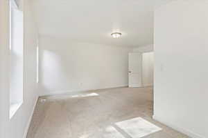 Unfurnished room featuring light colored carpet