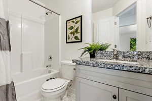 Full bathroom with vanity, toilet, and shower / bath combo with shower curtain